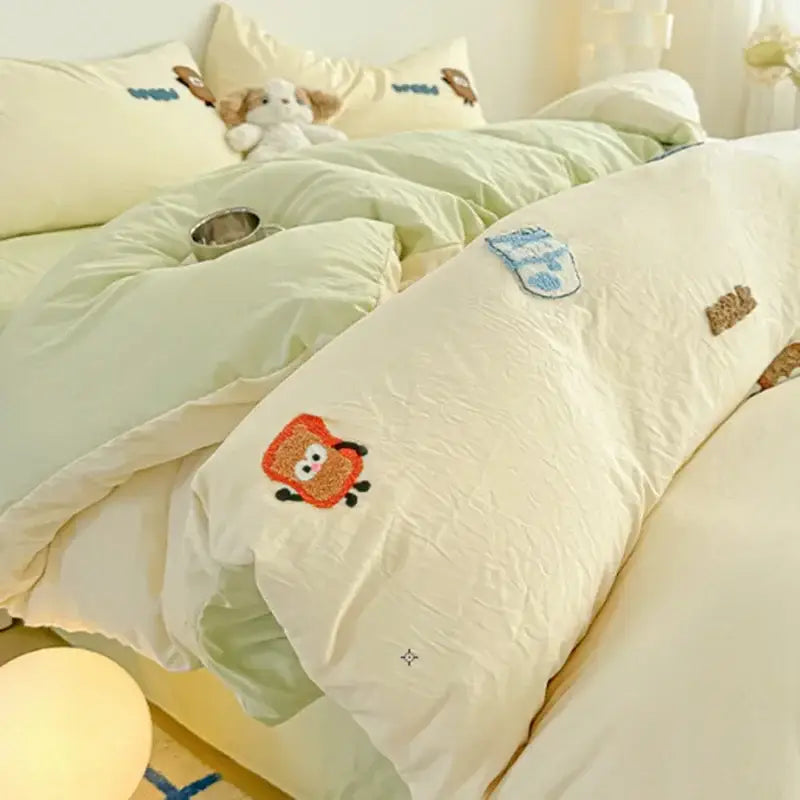 Cream cartoon embroidery jacquard comforter set featuring cream-colored quilt with embroidered cartoon characters and textured patches