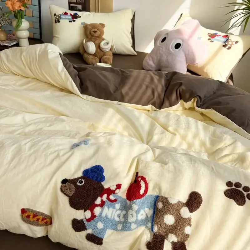 Cream cartoon embroidery jacquard quilt featuring a plush embroidered dog with a blue hat and polka-dot scarf