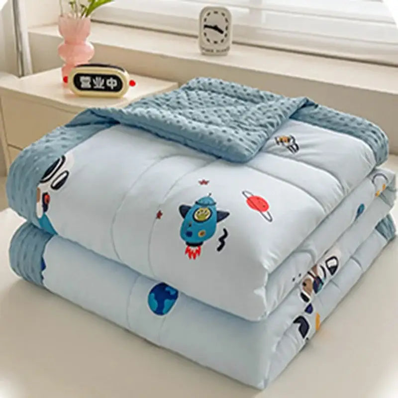 Cream cartoon pattern summer quilt in soft light blue featuring decorbites cartoon pattern of rockets and planets