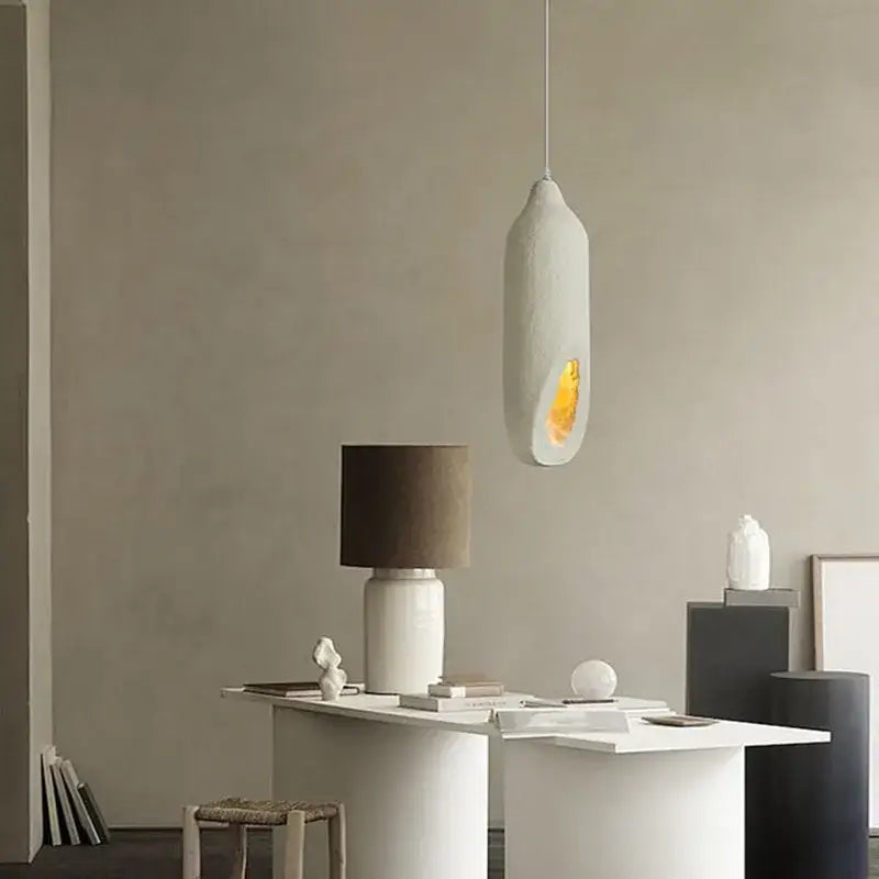 A sleek off-white cream ceramic pendant light with an amber glow from decorbites cement handmade led collection for living room