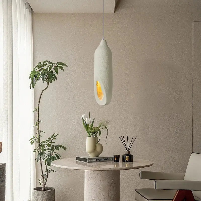 A cream ceramic pendant light with warm amber glow from decorbites cement handmade for living room decor