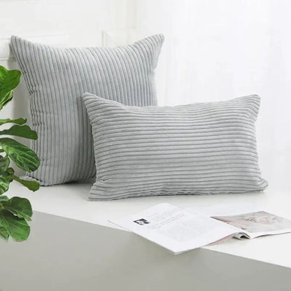 Two light gray decorbites corduroy striped cushion covers with vertical ribbed texture in square and rectangular shapes