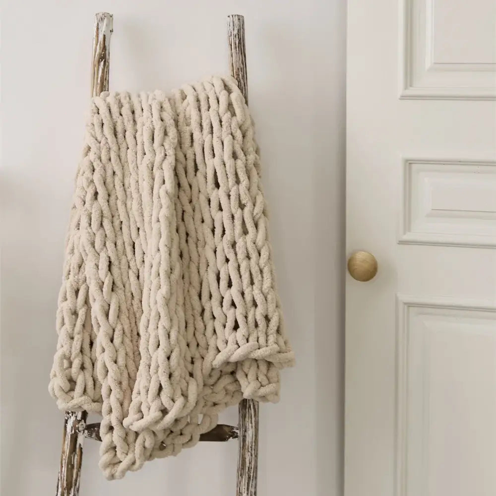 Cream cozy chenille chunky knit throw blanket in cream draped over rustic wooden ladder for bedroom decorbites cozy chenille