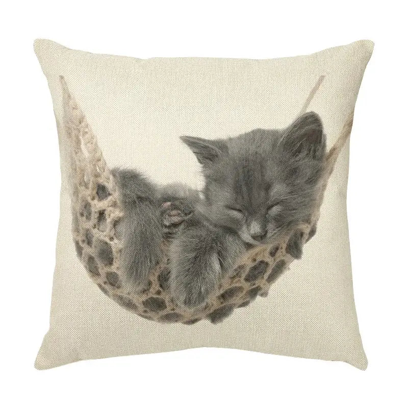 Beige linen throw pillow with cute cat face decorative print of gray kitten sleeping in woven hammock for living room