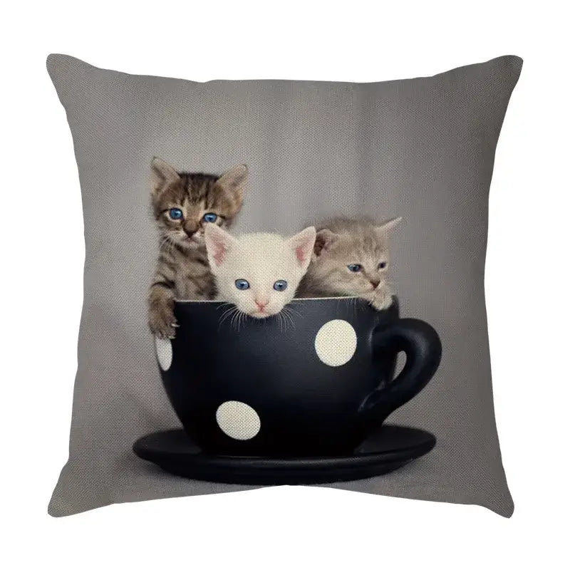 Gray throw pillow with a cute cat face decorative print of three kittens peeking from a black polka-dotted teacup