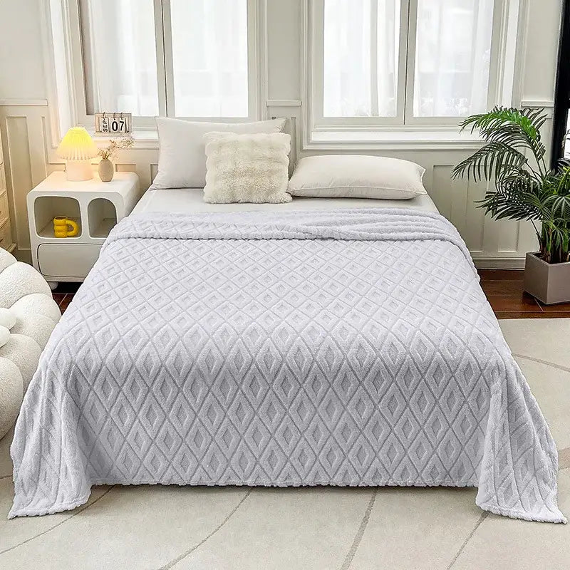 Soft light gray quilted throw blanket with diamond jacquard coral fleece pattern and plush texture for bedroom use