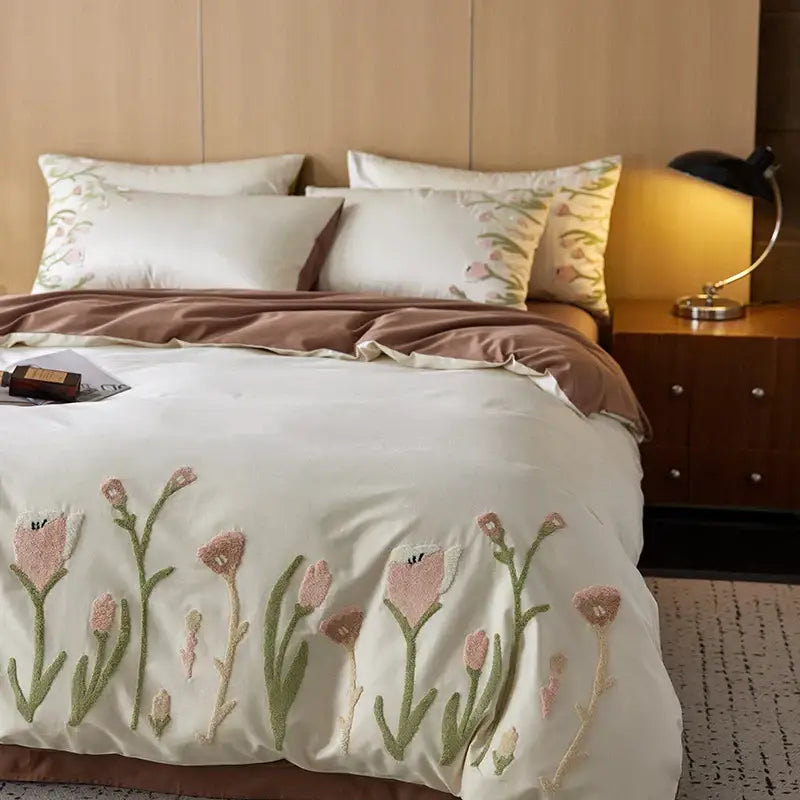 Cream egyptian cotton bedding set with cream duvet cover featuring pink and green tulip embroidery along bottom edge