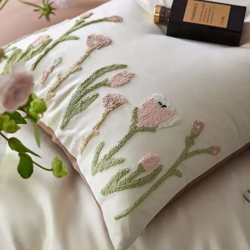 A cream egyptian cotton bedding set featuring a soft white pillow with delicate pink and green embroidered tulips