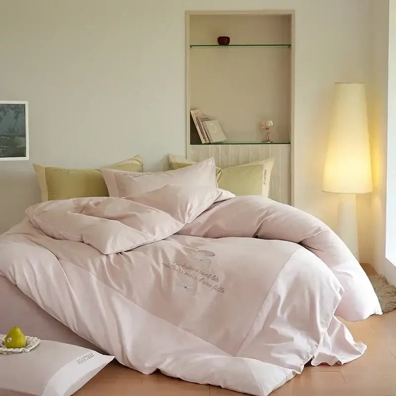 A soft blush pink satin bedding set with delicate embroidery and subtle sheen in decorbites brushed volcanic fleece