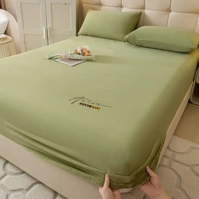 Light green satin-like decorbites cozy velvet fitted sheet with embroidered aotian fantasy logo in black and gold thread