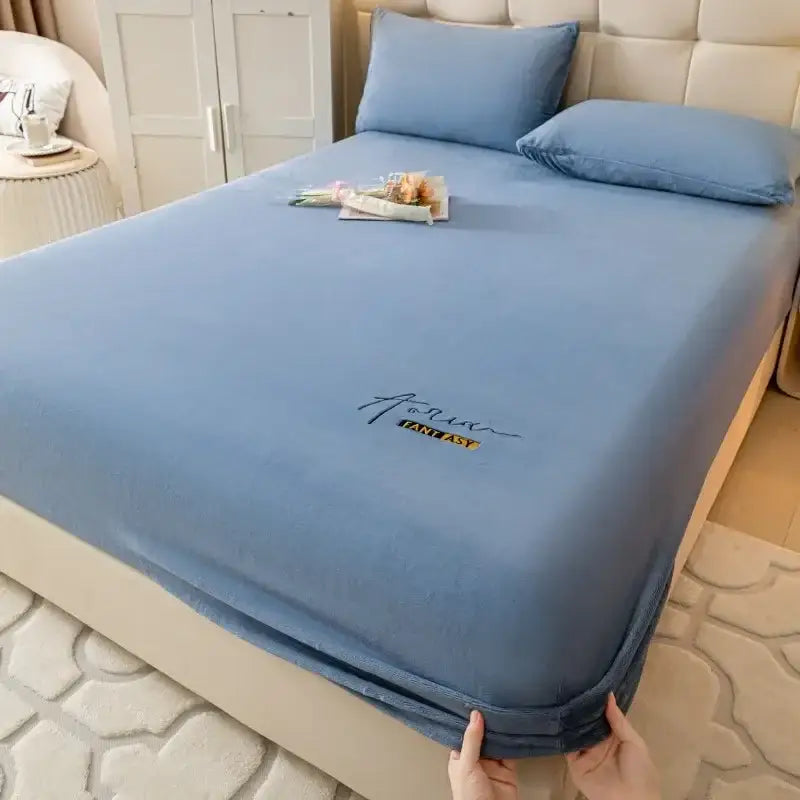 Light blue decorbites cozy velvet fitted sheet with soft texture and subtle fantasy logo embroidery in black and gold foil
