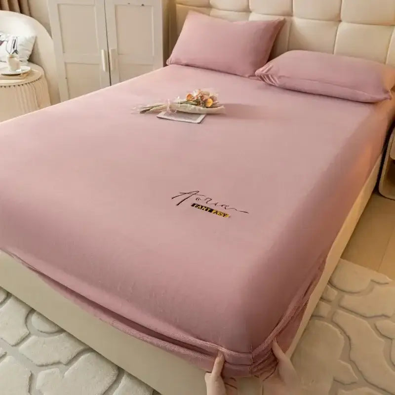 Pink satin fitted sheet with embroidered aqua fantasy logo in black and gold thread from decorbites cozy velvet collection
