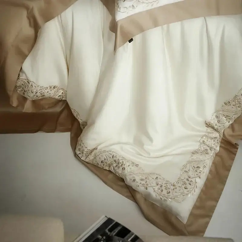 Cream embroidered egyptian cotton bedding set featuring a cream satin duvet cover with beige floral embroidery and tan border