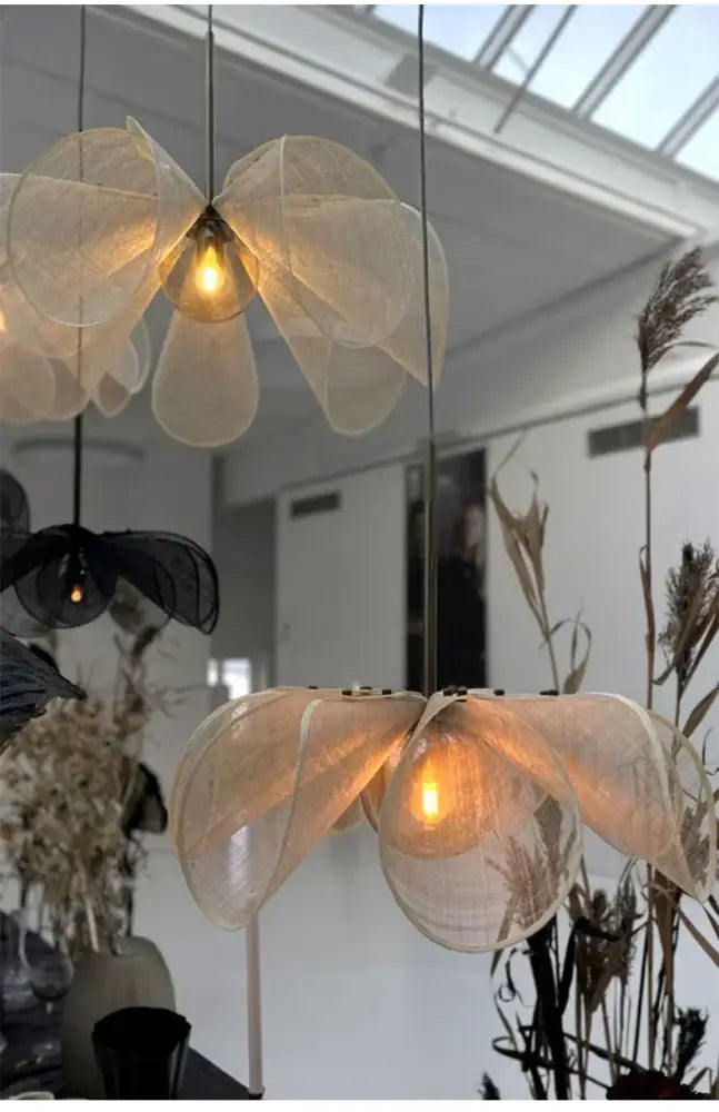 Cream fabric flower chandelier featuring delicate translucent fabric flower pendant lights with warm glowing bulbs