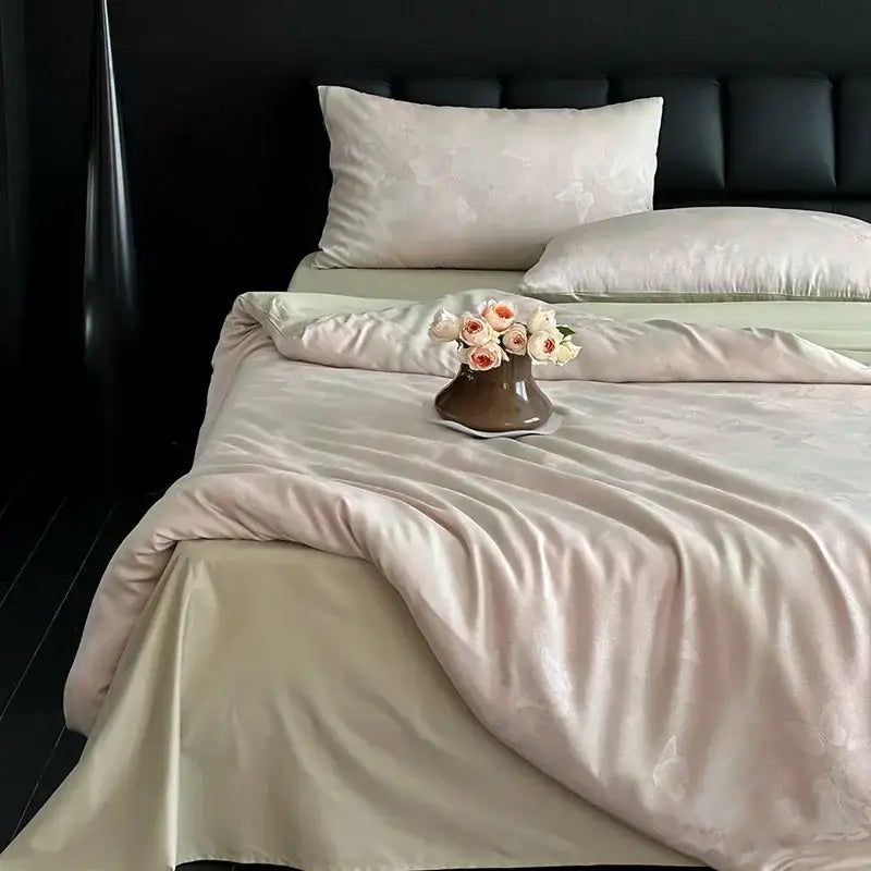 A cream floral cotton jacquard bedding set with peach and white roses in a matte brown ceramic vase on the bed