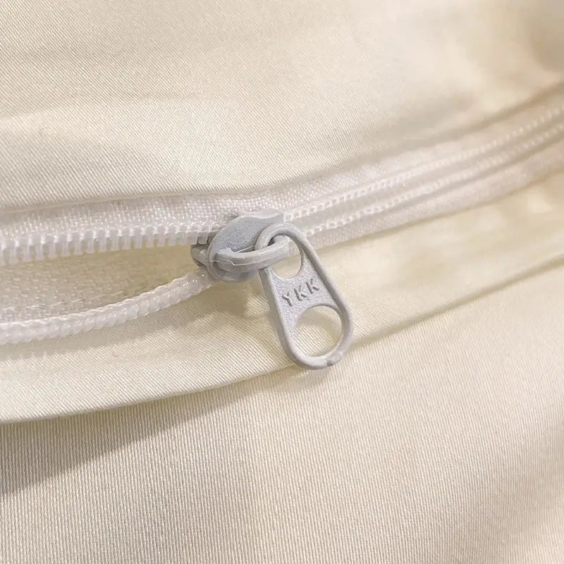 A silver-toned ykk zipper pull on white fabric in cream floral decorbites flowers embroidery silky duvet set
