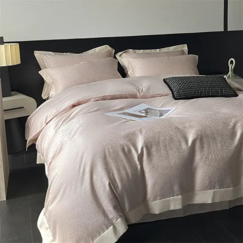 A luxurious blush pink satin decorbites jacquard bedding set with cream piping for elegant bedroom decor