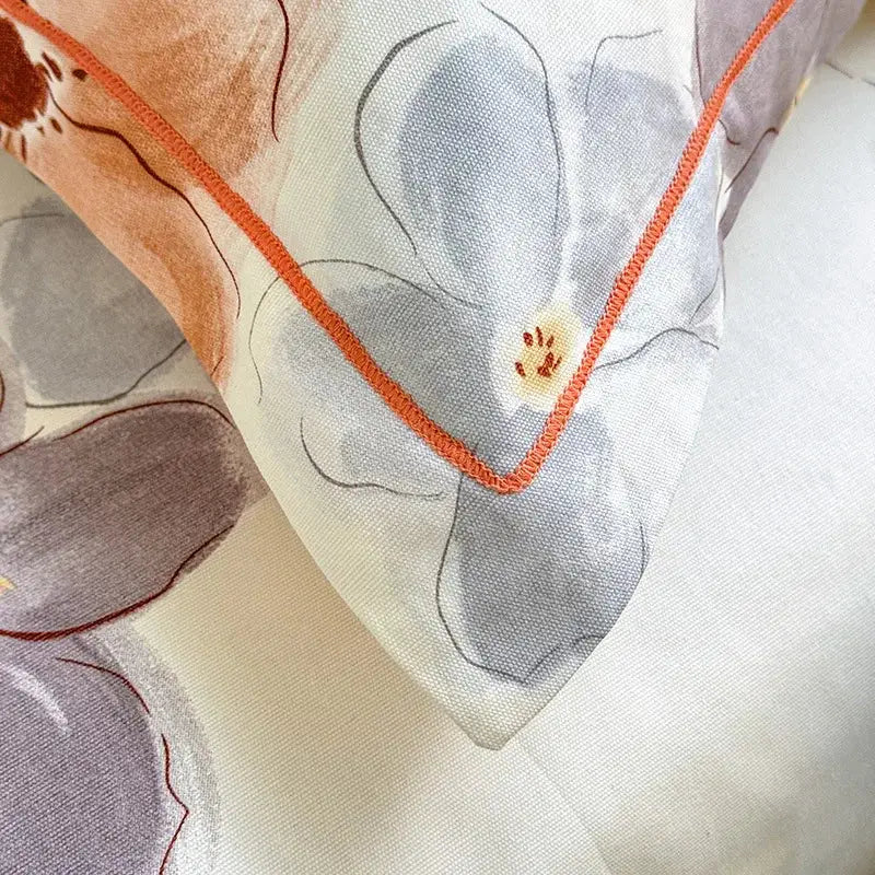 Cream flower print satin bed cover with a soft cream pillow sham featuring muted gray peach floral decorbites cooling cotton trim