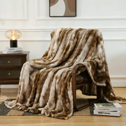 A mottled brown and cream decorbites fuzzy faux fur blanket draped over an armchair for bedroom and living room decor
