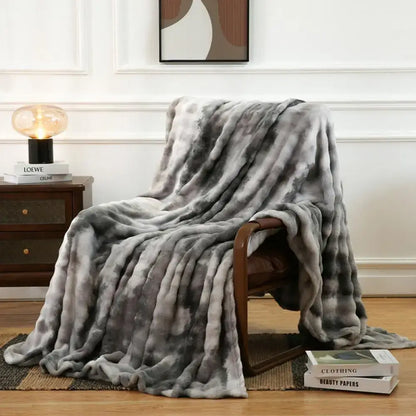 A plush gray gradient fuzzy faux fur blanket draped over a wooden chair perfect for bedroom and living room decorbites fuzzy faux use