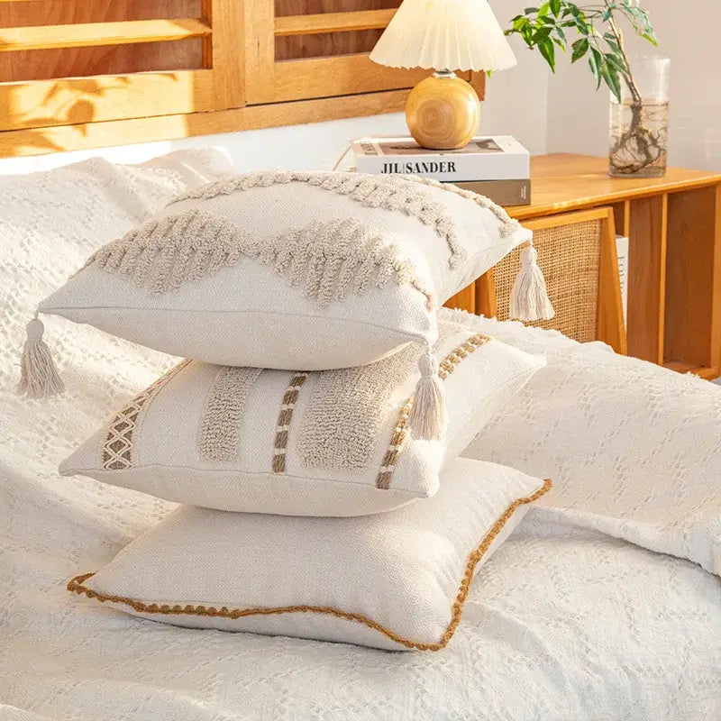 Stacked off-white decorbites geometric tufted cushion covers with macrame fringe tassels and textured embroidery for living room decor