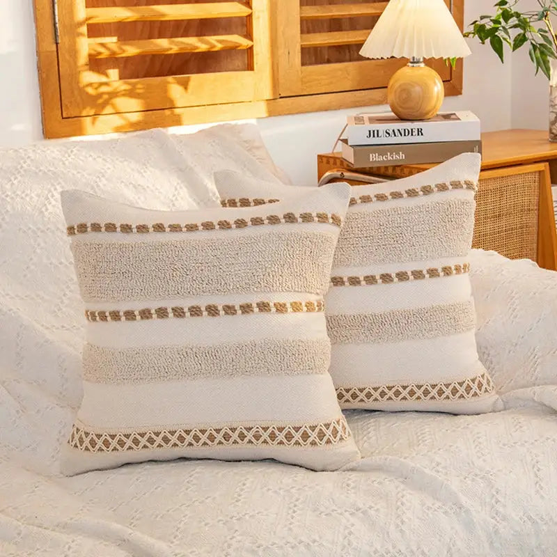 Cream geometric tufted cushion cover with cream-colored textured throw pillows and beige embroidered details for living room decorbites