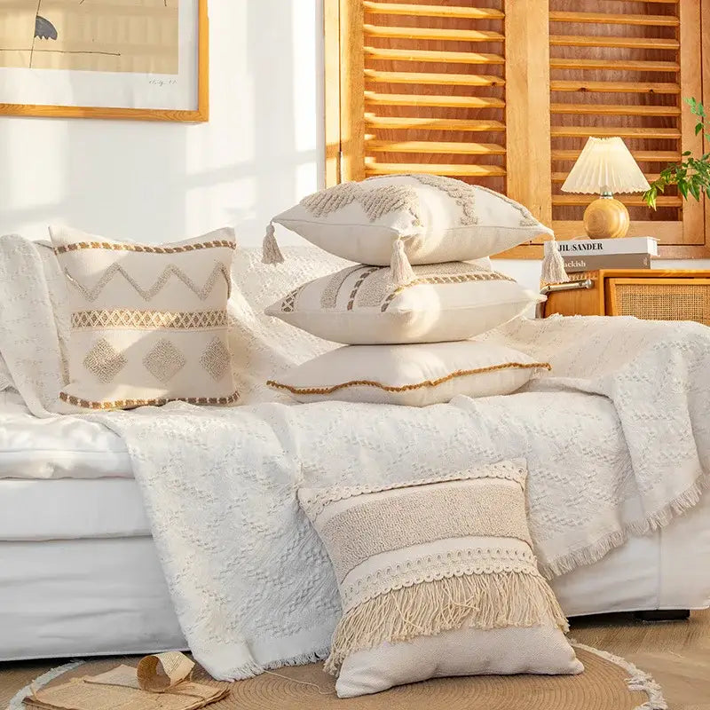 Beige cream geometric tufted cushion cover with macrame fringe and tassels stacked on white couch for decorbites decor