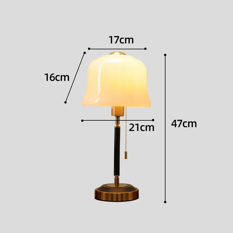 Cream glass mushroom table lamp with a warm glowing bell-shaped shade brass and black decorbites cream glass design