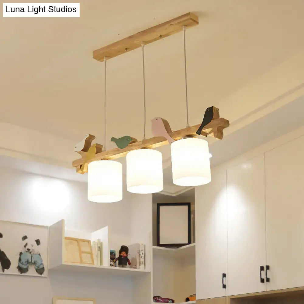 DecorBites Simplicity cream glass LED hanging lamp with wooden bird accents and white cylindrical shades on natural wood branch