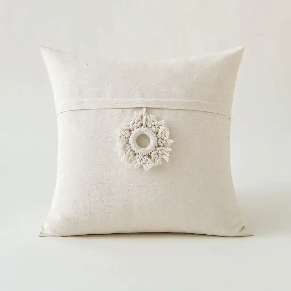 Off-white canvas pillow cover with delicate macrame wreath pendant and decorbites ivory pompom tassel decor