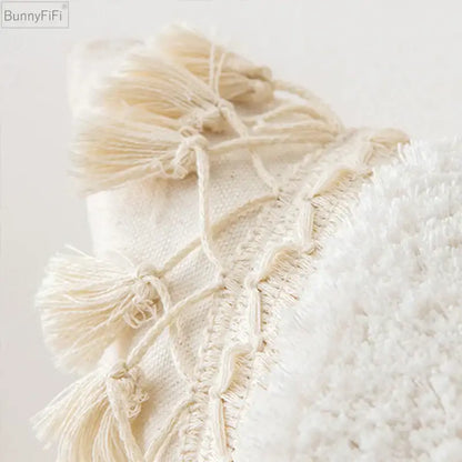 Cream-colored woven pillow cover with ivory pompom tassel and fluffy white fabric accents for living room decorbites decor