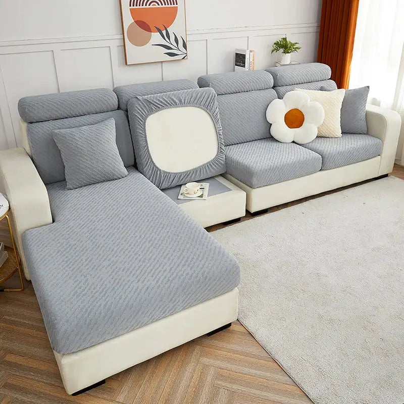 Gray textured jacquard l sofa cover with white square cutout on back cushion and matching sofa seat cover pillows