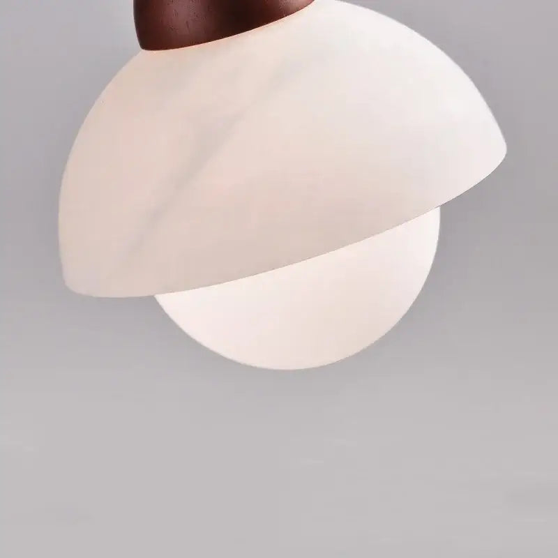 A modern cream marble led pendant light with matte white glass shade and dark bronze fixture for bedroom decorbites