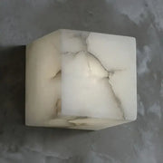 Cream onyx cube marble wall lamp with natural veining and prominent crack for elegant bedroom decorbites cube marble sconce