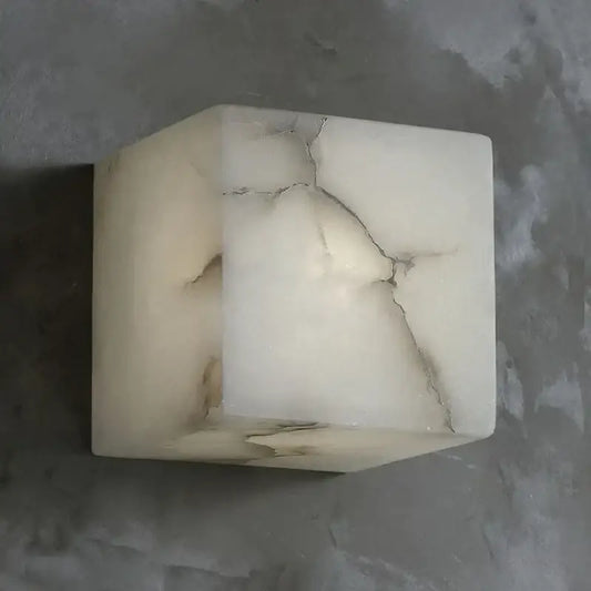 Cream onyx cube marble wall lamp with natural veining and prominent crack for elegant bedroom decorbites cube marble sconce