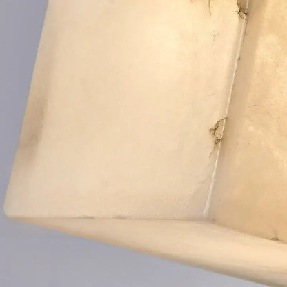 Cream onyx marble cube led wall sconce with cream-colored textured rectangular tray showing worn edges for bedroom lighting