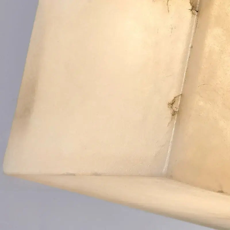 Cream onyx marble cube led wall sconce with cream-colored textured rectangular tray showing worn edges for bedroom lighting