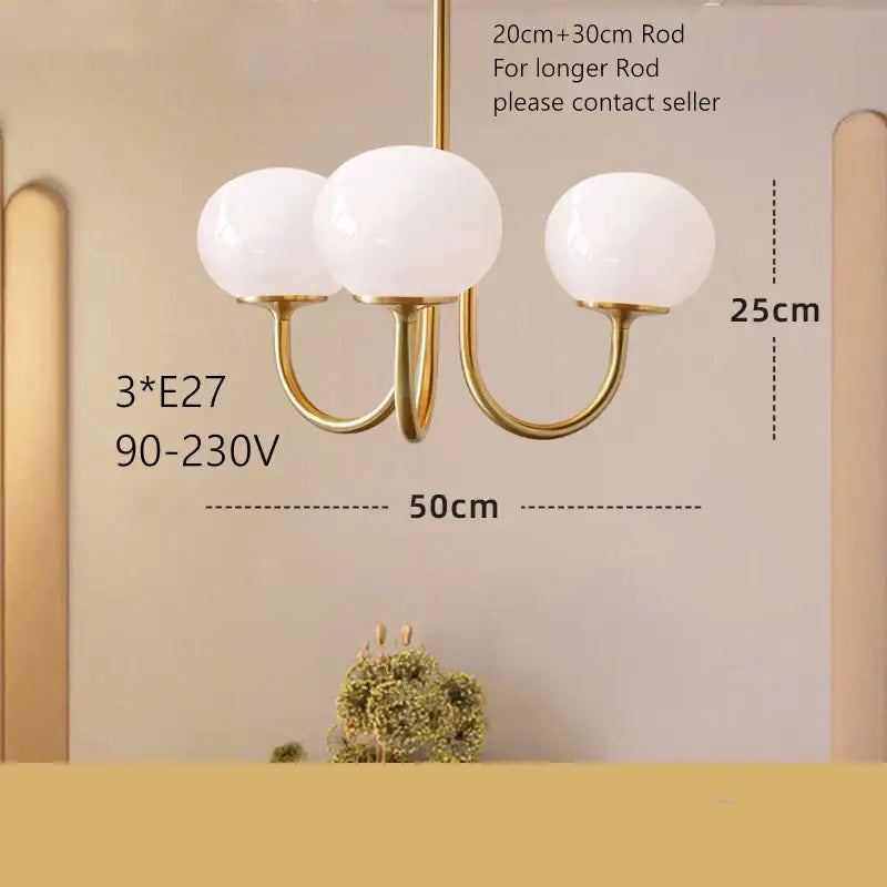 Gold-toned pendant light with three frosted white glass globes for cream pink bedroom decor by decorbites