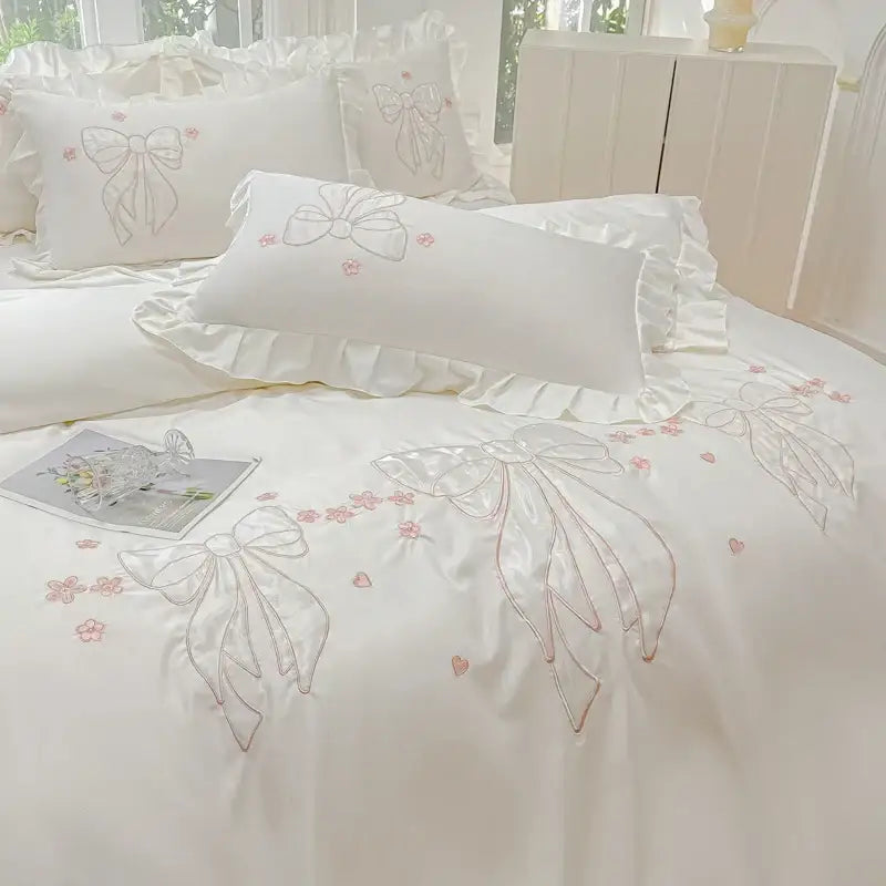 Cream and pink ice silk embroidered ruffles duvet set with white satin bedding featuring bows and floral accents