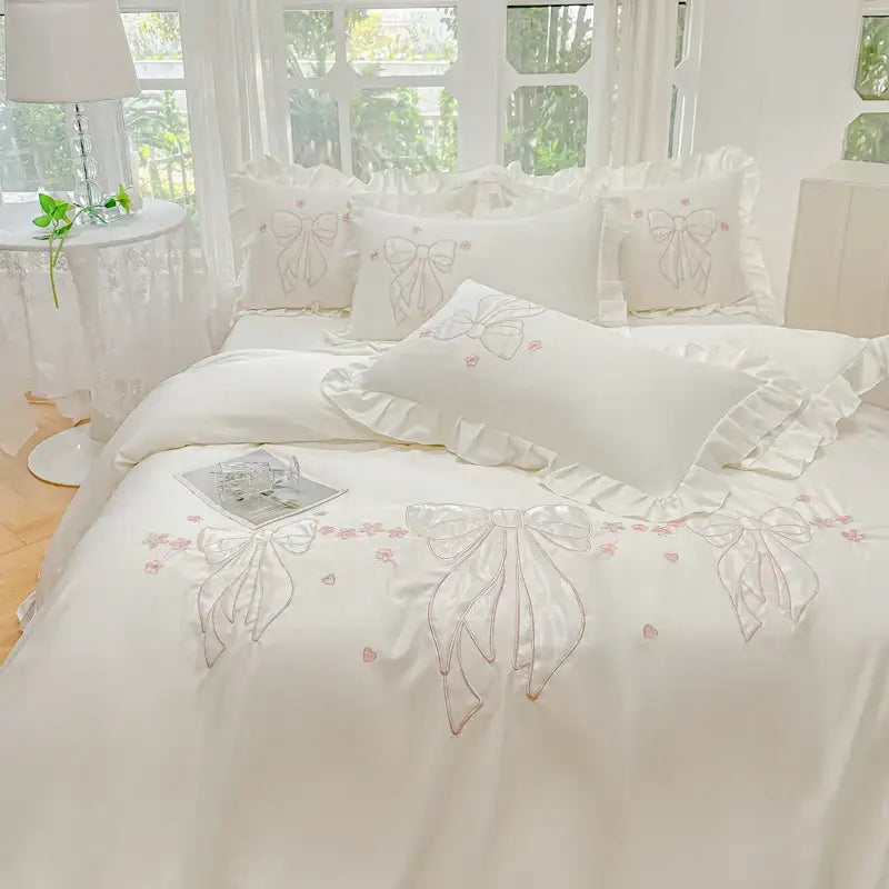 Cream and pink ice silk duvet set with white satin fabric, embroidered ruffles, bows, and floral accents for bedroom bedding