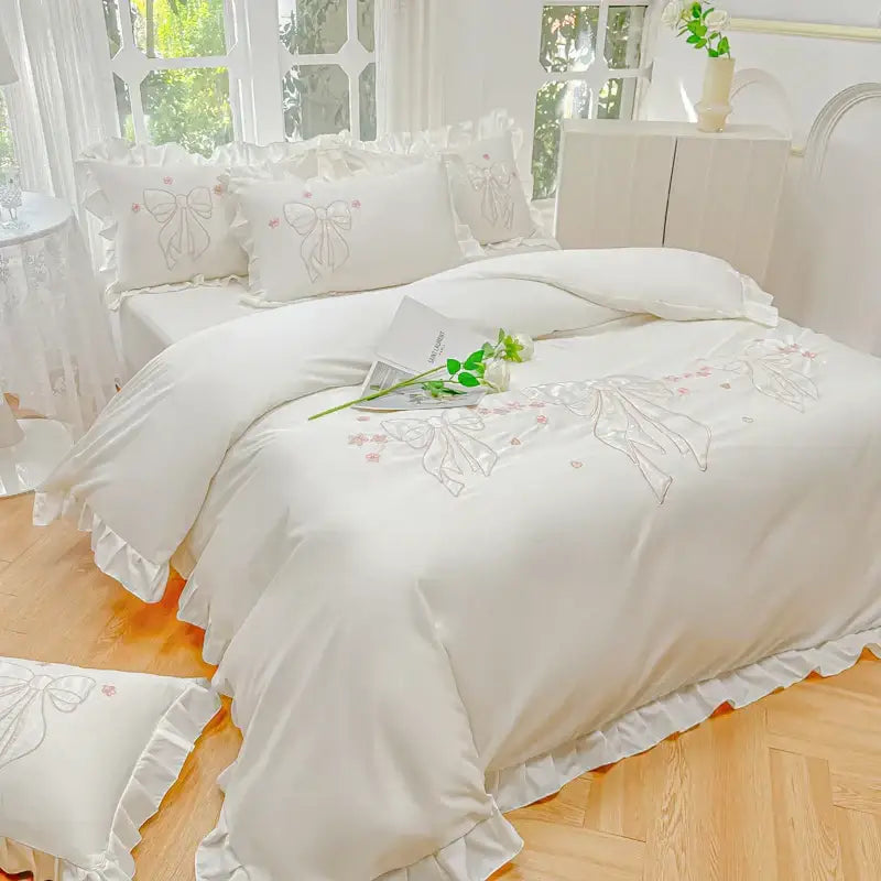 Cream and pink ice silk duvet set with white satin, embroidered ruffles, lace trim, and delicate pink bow designs