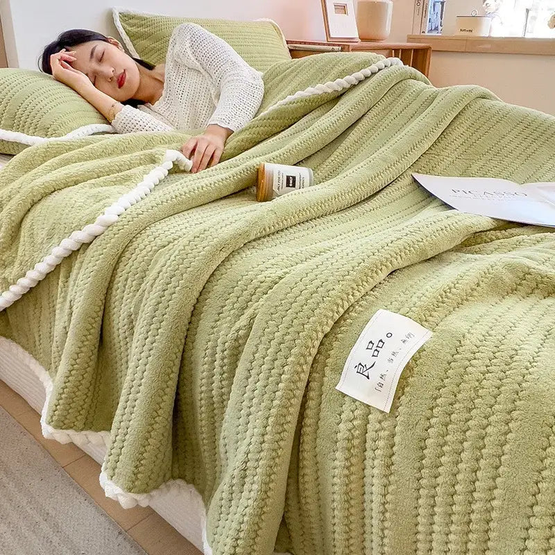 Soft mint green throw blanket with white pom-pom trim featuring double sided jacquard milk velvet texture