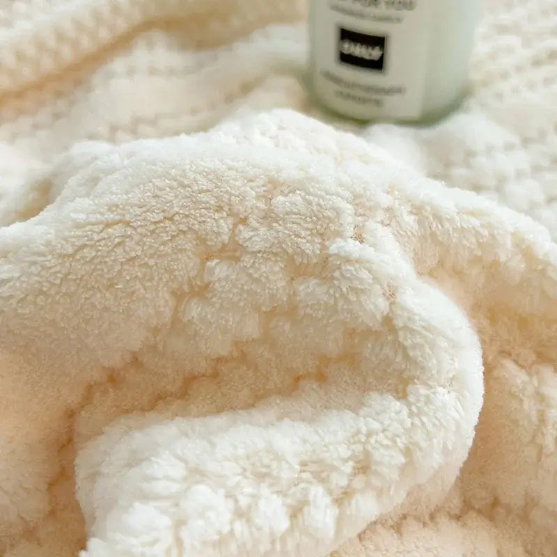 Cream plush double sided jacquard milk velvet blanket with a soft textured surface for bedroom throw use