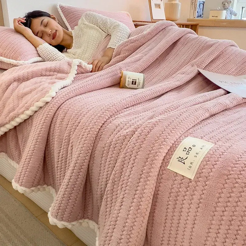 Pink textured knit blanket with white braided trim featuring soft double sided jacquard milk velvet fabric for bedroom throw