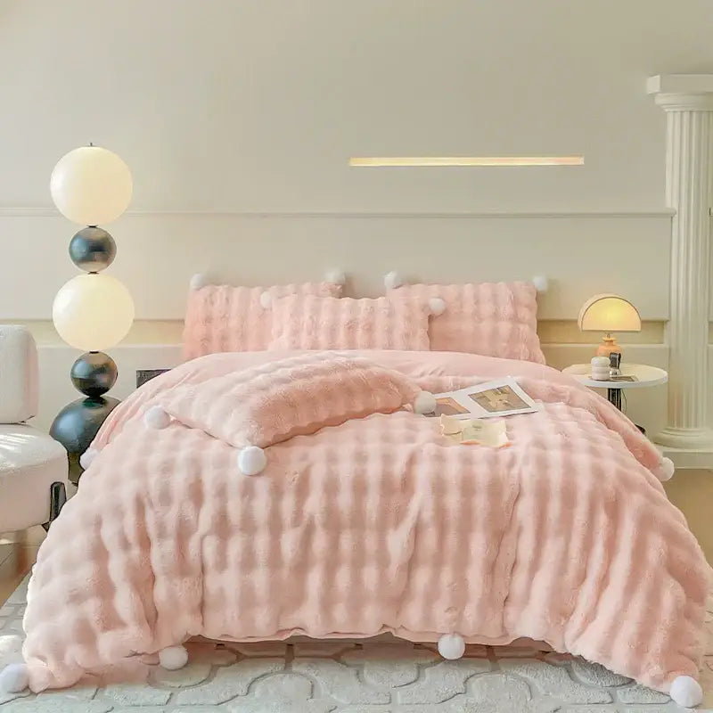 Cream plush rabbit fur bedding set with pink textured quilt and white pom-pom accents luxury fur bedding set
