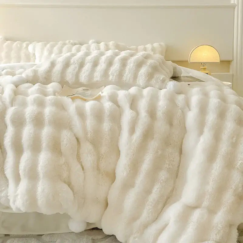 Cream plush rabbit fur bedding set featuring a white textured faux fur throw blanket with a wavy pattern