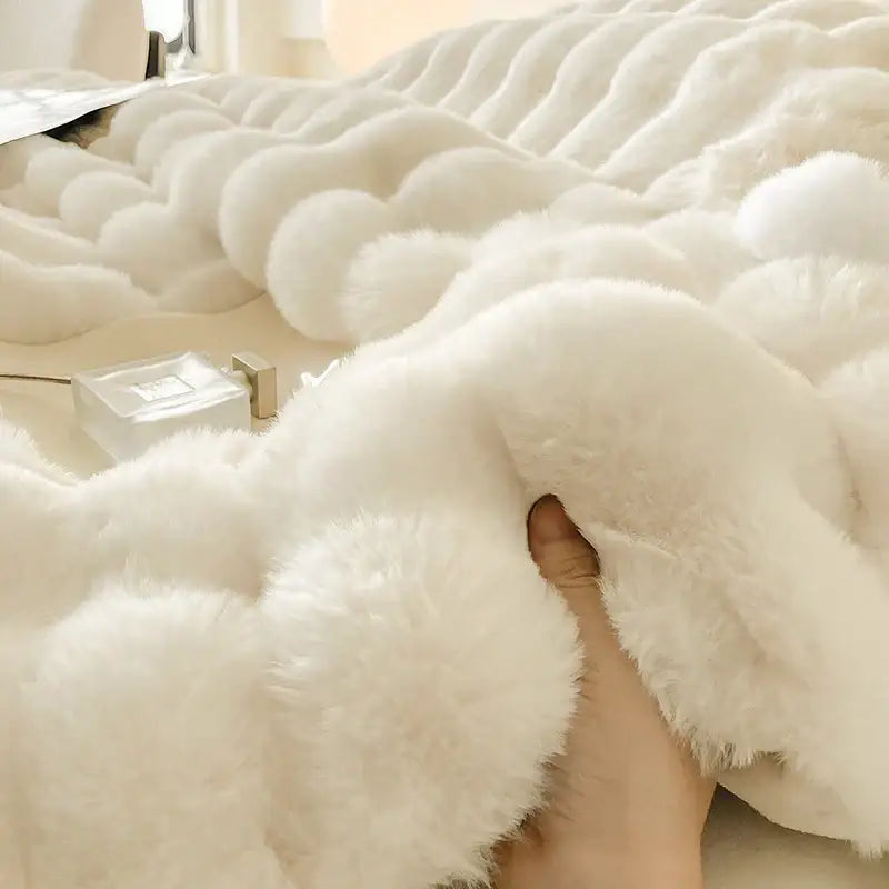 Cream plush rabbit fur bedding set featuring a white faux fur throw blanket with soft wavy texture and luxurious feel