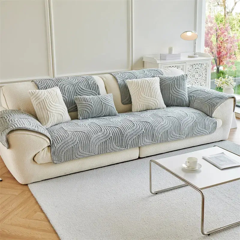 Beige sofa with a cream quilted wave plush cover and matching gray textured pillows for living room use