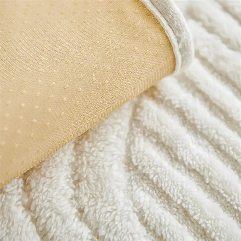 Cream quilted wave plush sofa cover featuring soft beige fabric with subtle dotted texture and white fleece edging