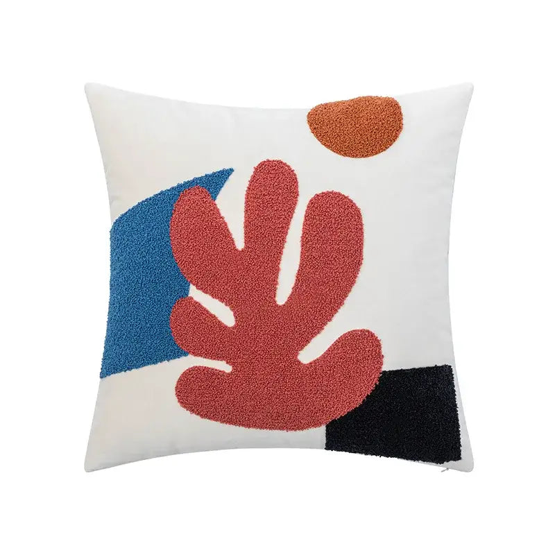 A square white cushion cover with cream rainbow cartoon abstract embroidery featuring bold red blue and black shapes